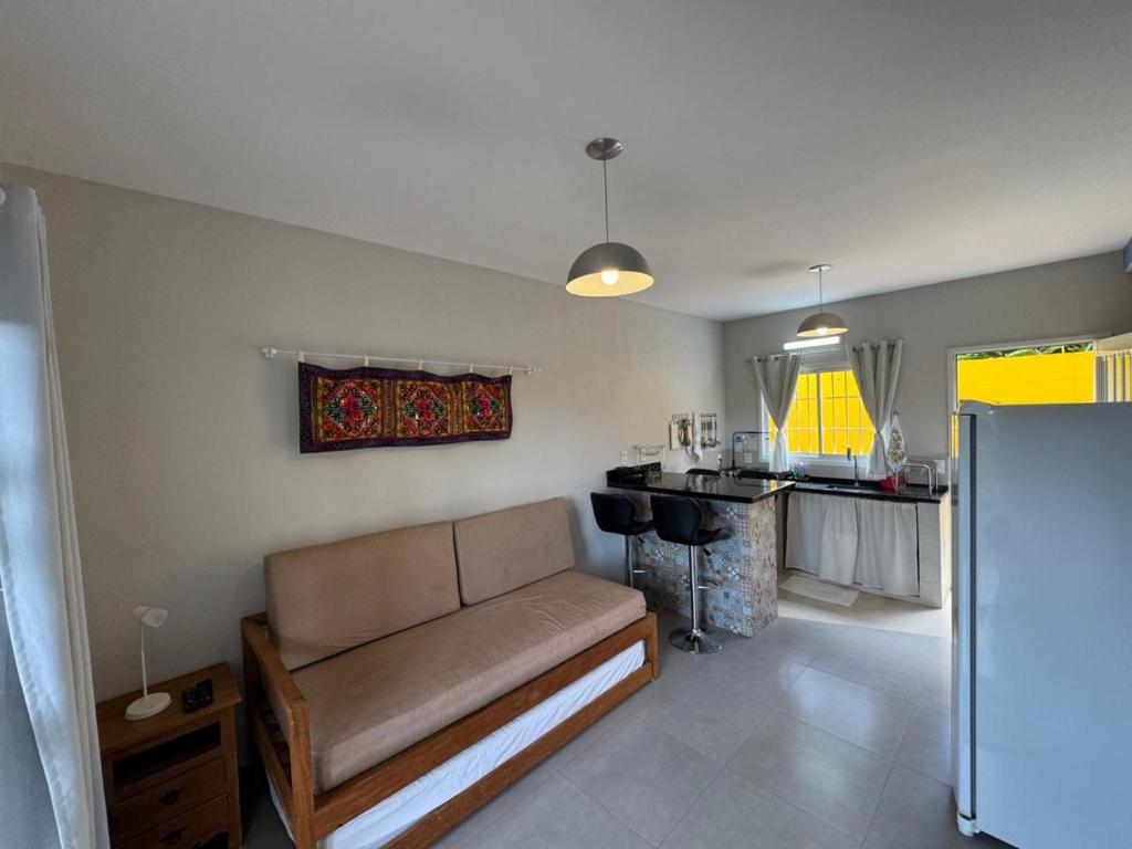 a living room with a couch and a kitchen at Vila dos Cristais - Apartamentos de Temporada in Alto Paraíso de Goiás