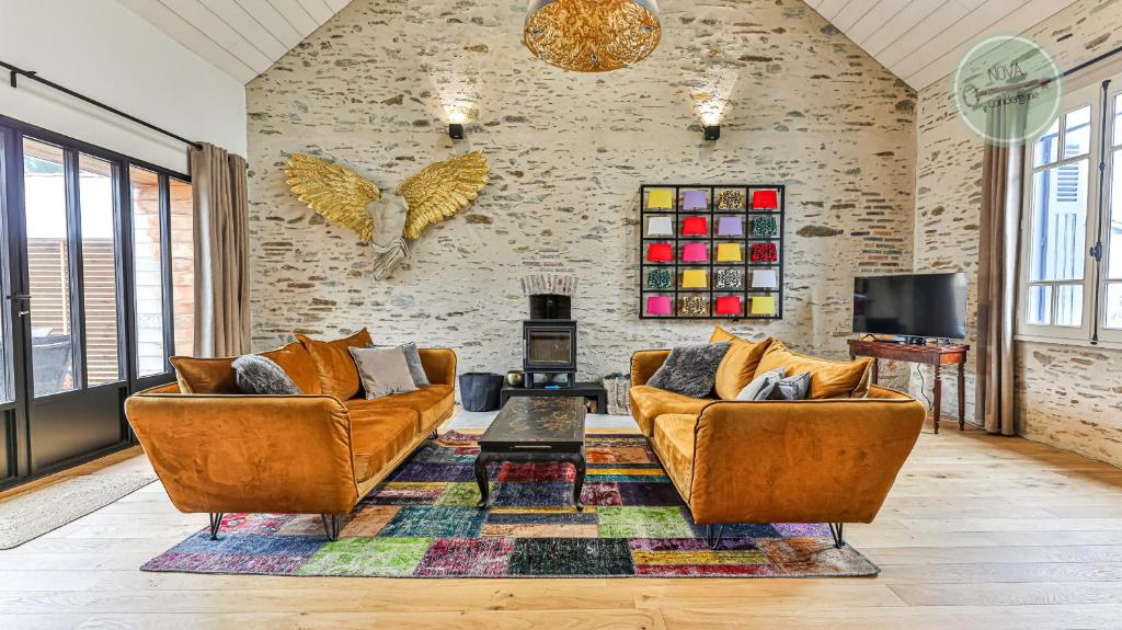 een woonkamer met twee banken en een tv bij Villa Floreal in Saint-Gilles-Croix-de-Vie