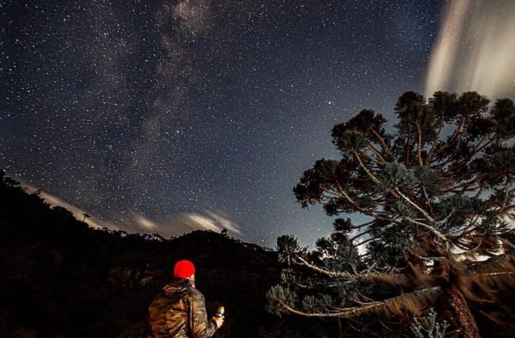 a person is looking up at the night sky at Pousada Quinta das cores in Urubici