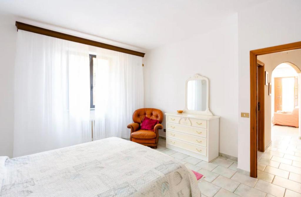 um quarto com uma cama, uma cadeira e uma cômoda em Appartamento con giardino em Pomarance