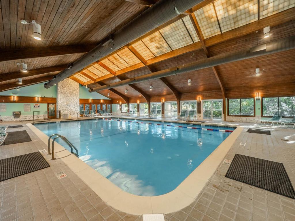 a large swimming pool in a large building with wooden ceilings at Ocean Dunes 306 in Kure Beach
