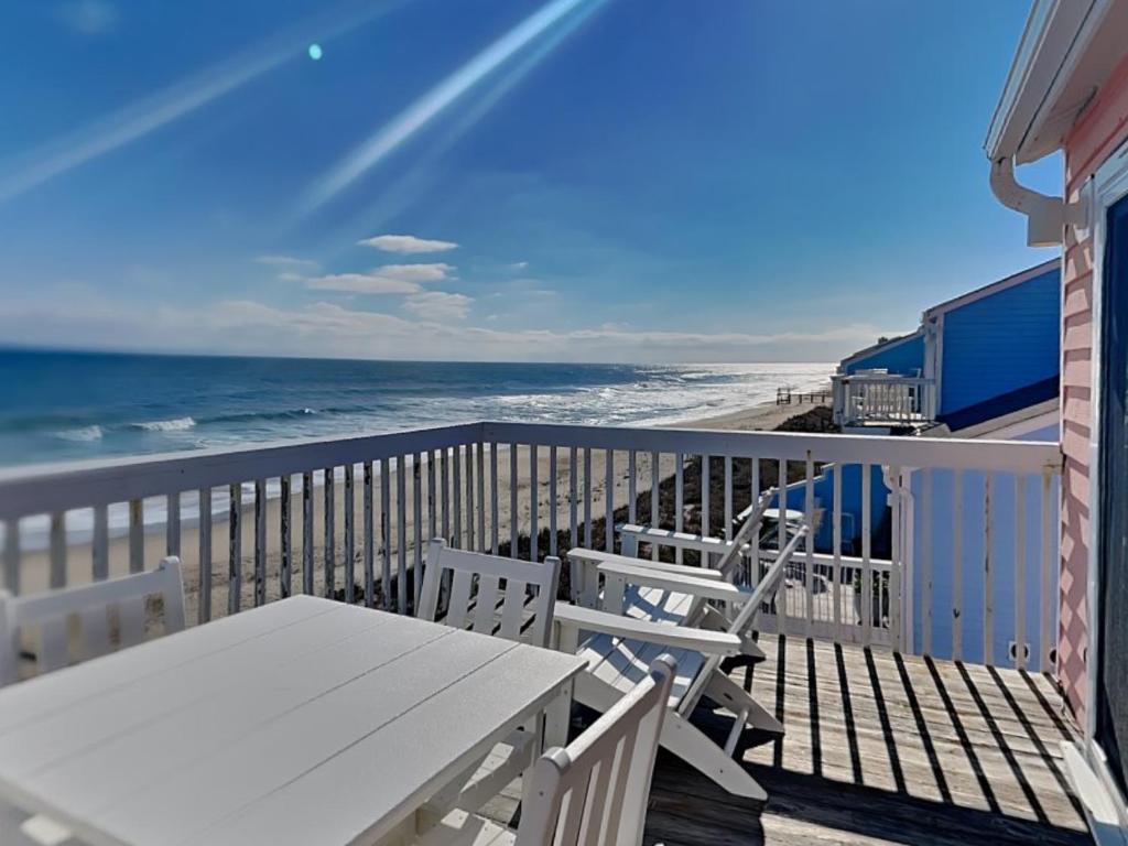 a balcony with a table and chairs and the beach at Ocean Dunes 306 in Kure Beach