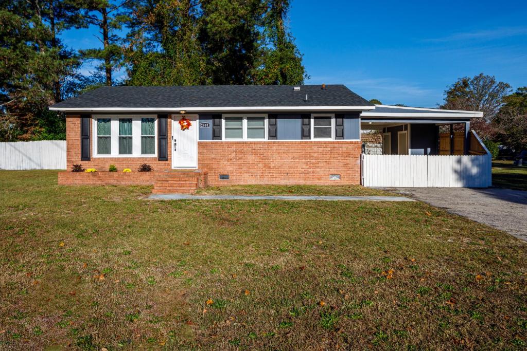 a brick house with a white fence at Cozy Vintage Ranch in Fayetteville