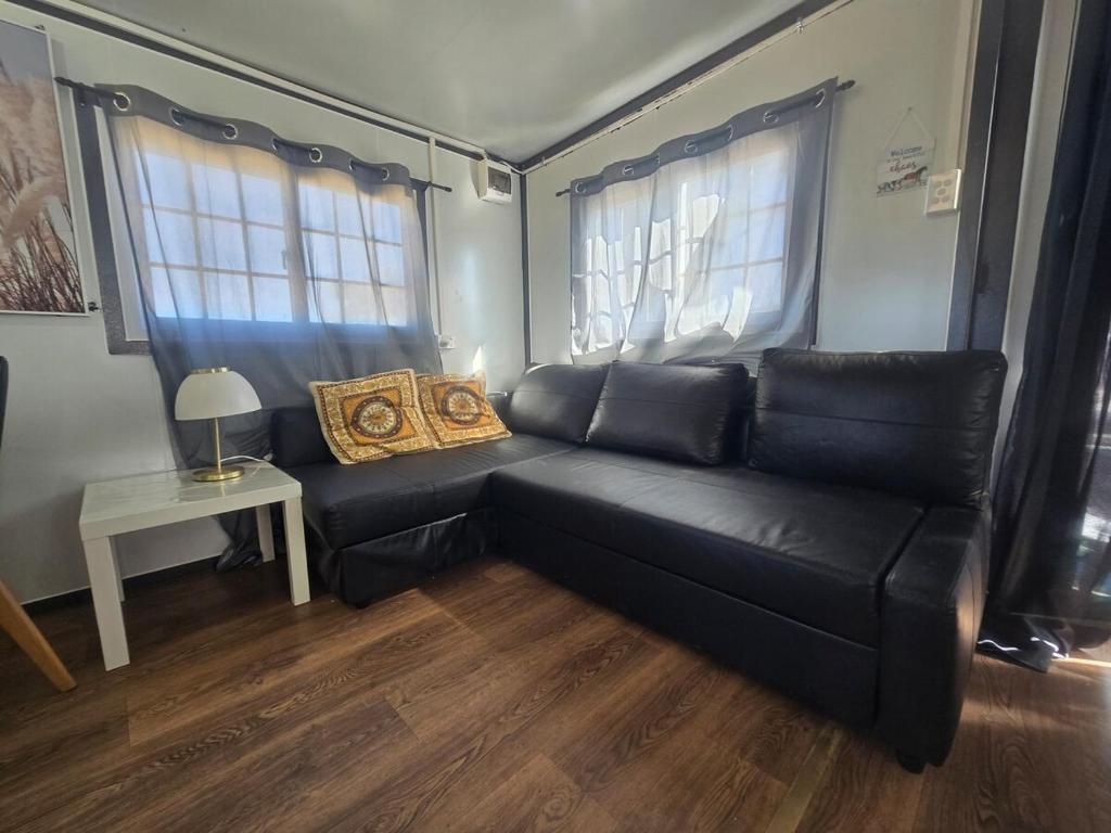 a black couch in a living room with a table at The Country Nook in Manildra