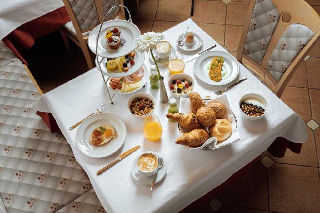uma mesa com pratos de café da manhã sobre ela em Apartment Hotel Elvis em Ortisei