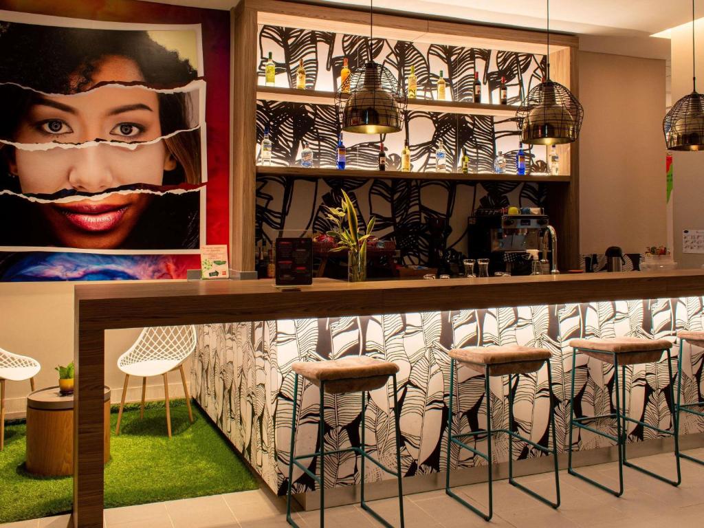 a bar in a restaurant with stools at ibis Apartado in Apartadó