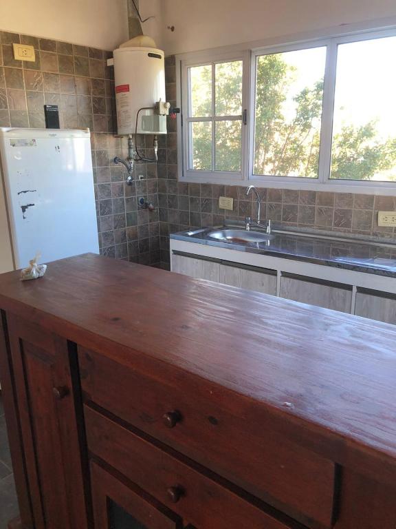 eine Küche mit einer Holzarbeitsplatte und einem Kühlschrank in der Unterkunft Hogar de luz in Olavarría