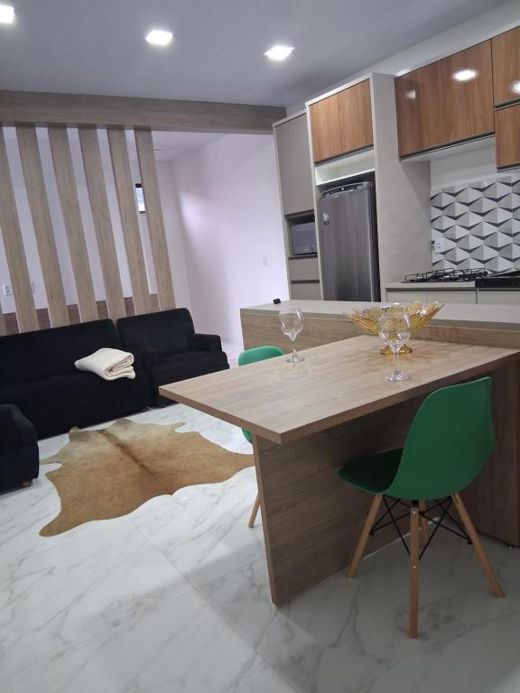a kitchen with a wooden table and green chairs at Apartamento moderno próximo ao centro in União da Vitória