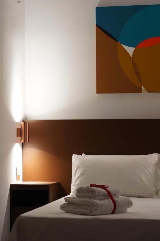 ein Schlafzimmer mit einem Bett, auf dem Handtücher liegen in der Unterkunft Rooms Around in Neapel