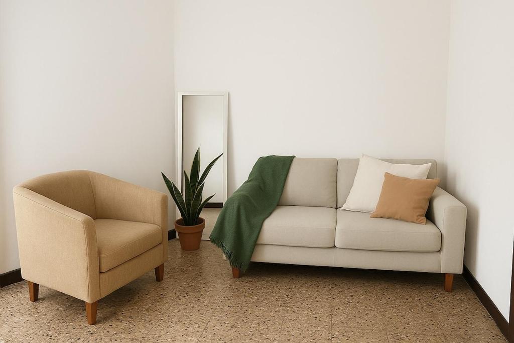 a living room with a couch and a chair at Departamento a media cuadra de plaza central in Tandil