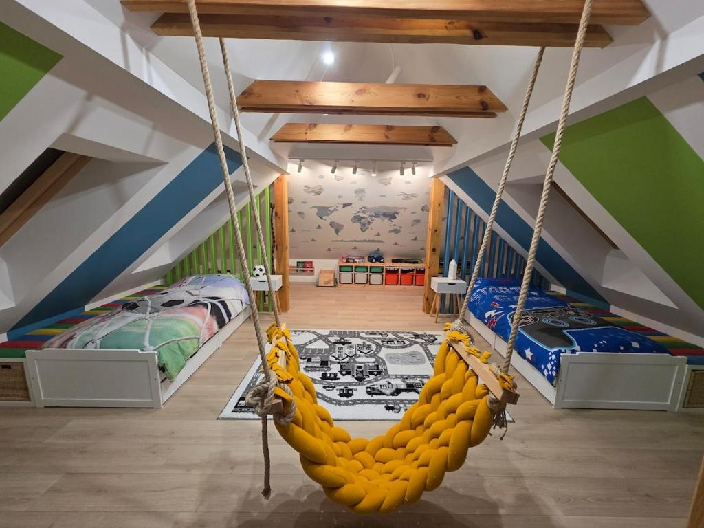 een kamer met 2 bedden en een schommel bij Loft Haven - Loftowa przystań in Trzemeszno