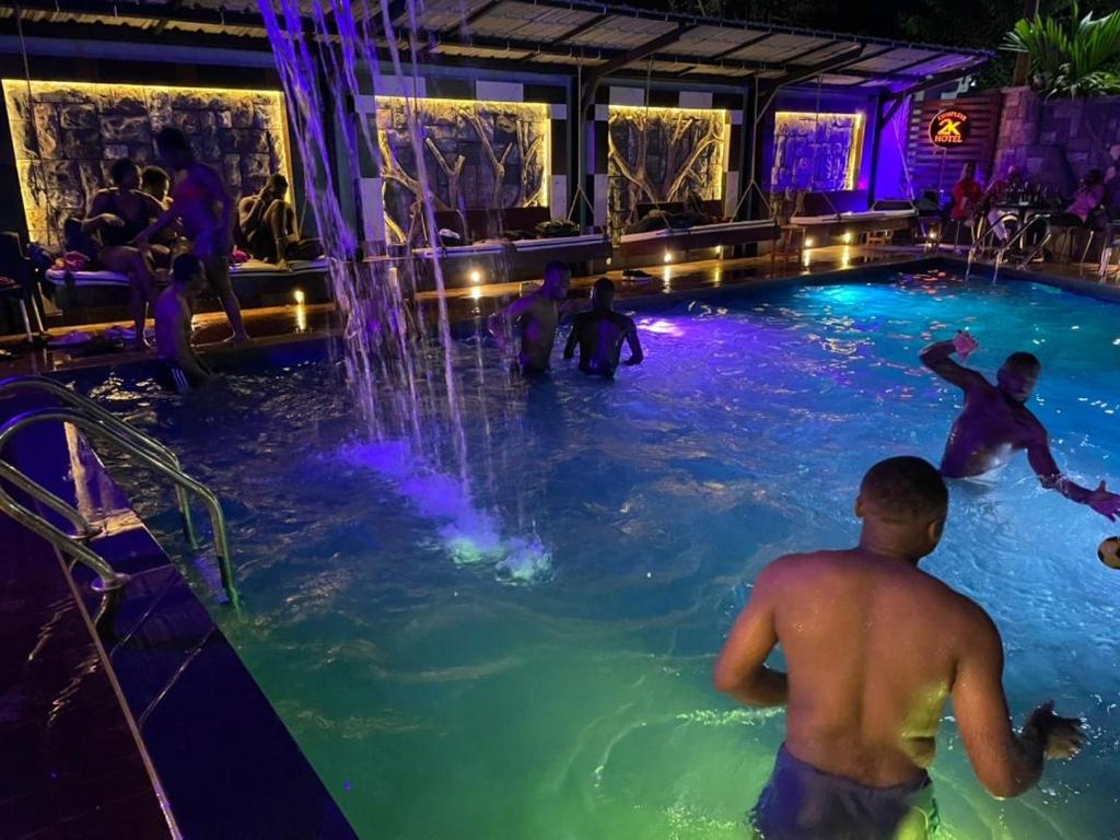 un grupo de personas jugando en una piscina en Hôtel 2K, en Yaoundé