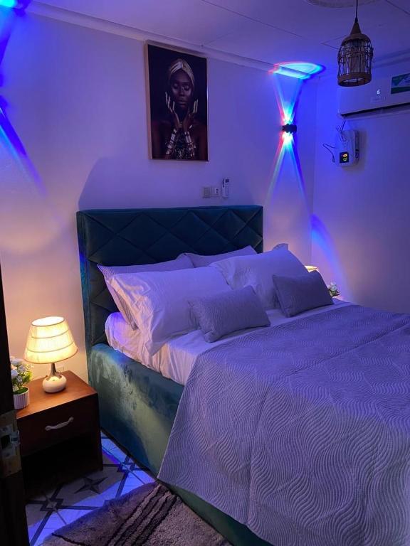 una camera da letto con un letto con luci viola di I&J Resort VIP a Yaoundé