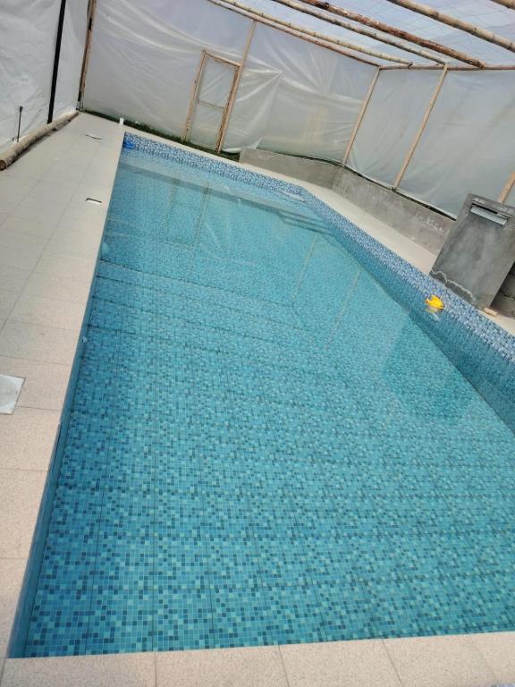 a large swimming pool inside of a tent at Coney Camping in Ambato
