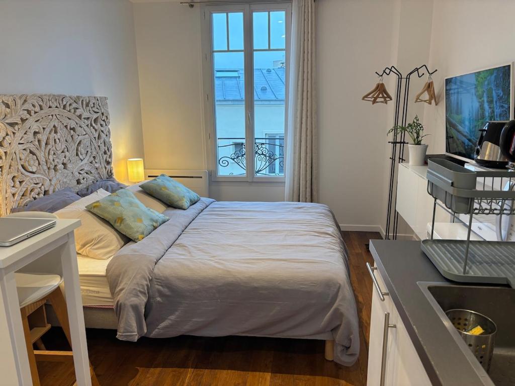 a bedroom with a large bed with a window at Charmant studio - Vanves in Vanves