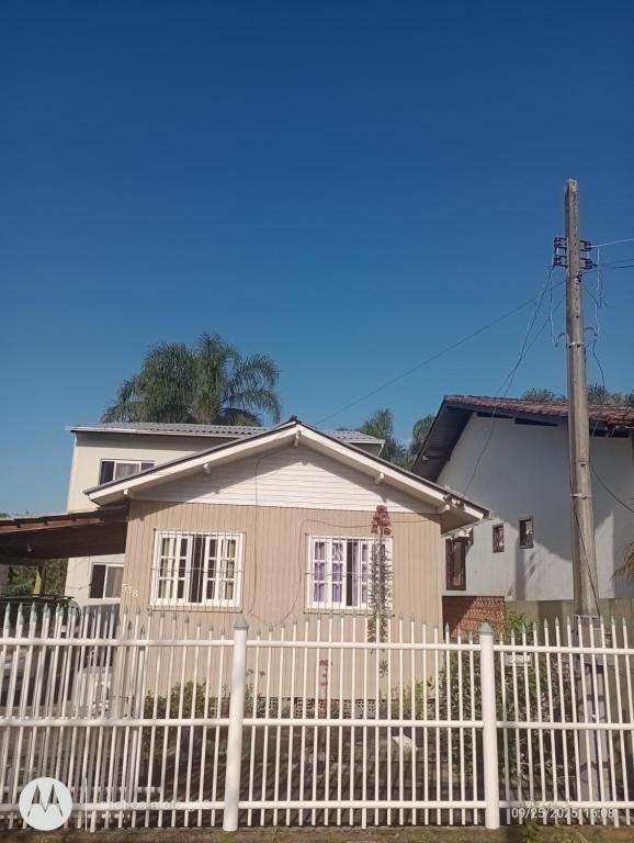 una valla blanca delante de una casa en Casa próximo ao Aeroporto, en Florianópolis