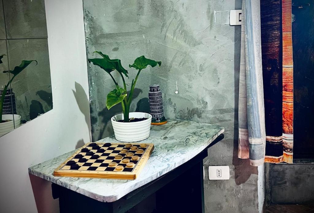 een schaakbord op een tafel met een potplant bij Gli occhi del vulcano in Linera