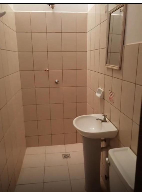 a bathroom with a sink and a toilet and a mirror at Hostal FINI in Trinidad