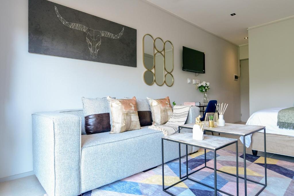 een woonkamer met een bank en een bed bij FezatOceanZimbali in Ballito