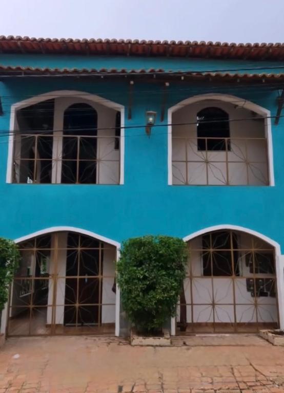 a blue building with two windows and a bush at Residencial Filhos da Lua in Lençóis