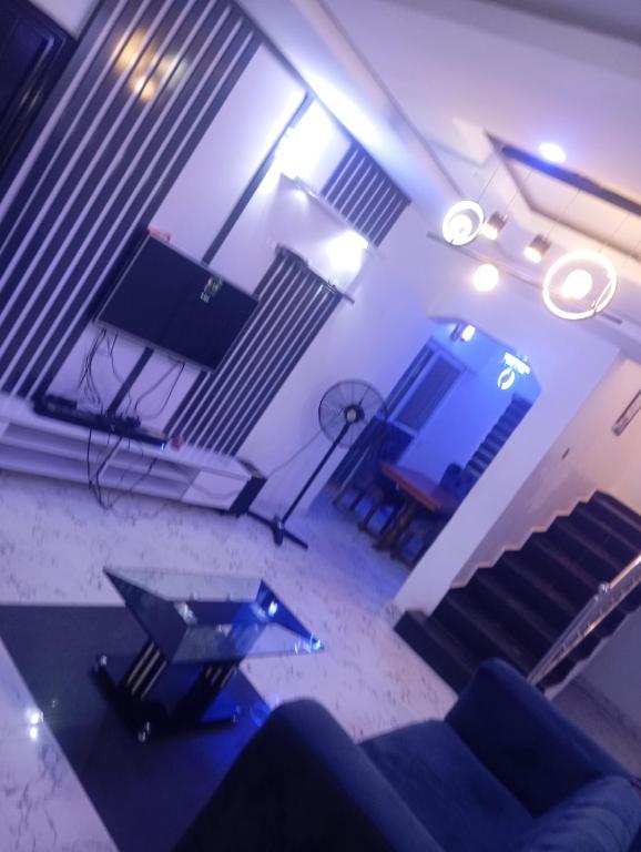 a living room with a couch and a television at Luxury 3 Bedroom Duplex at Thinkers Corner in Enugu