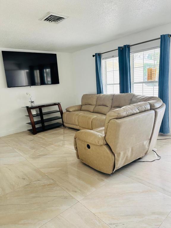 a living room with a couch and a flat screen tv at Discovery Cove Sarasota in Sarasota