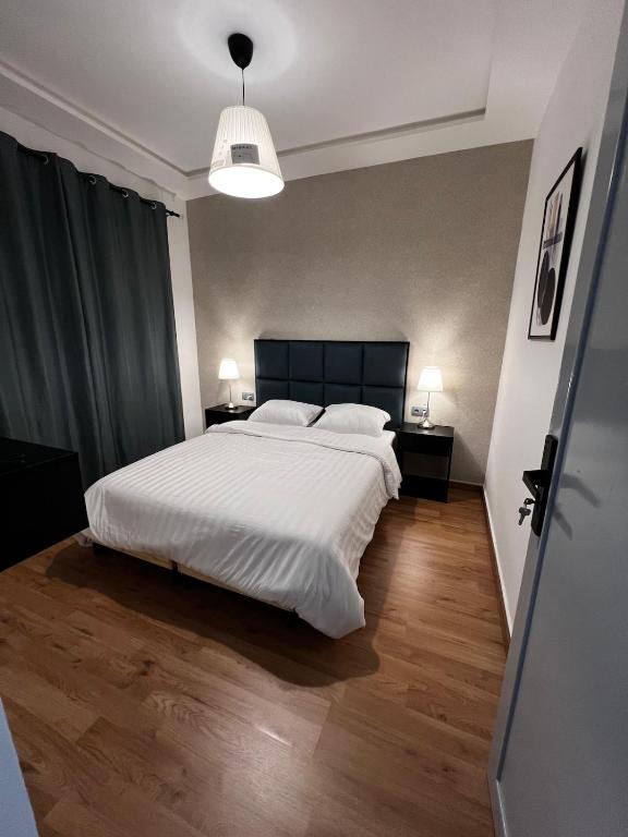 a bedroom with a large white bed and two lamps at Spacious apartment in Tétouan
