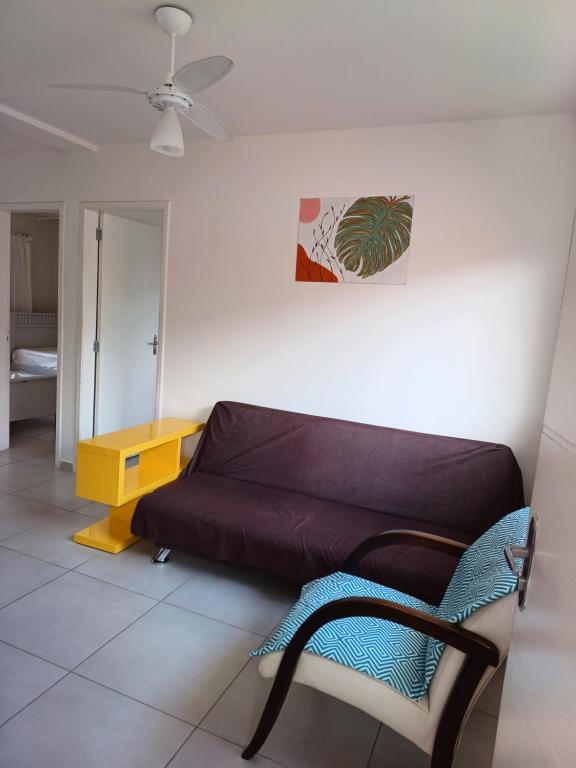a living room with a couch and a table at Apartamento superior Boracéia in Bertioga