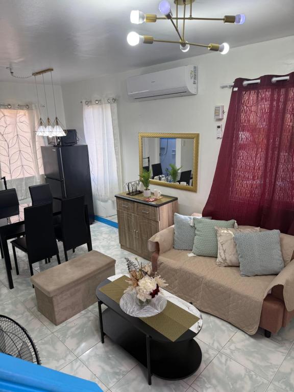 a living room with a couch and a dining room at Joy's Home Rental in Tagbilaran City