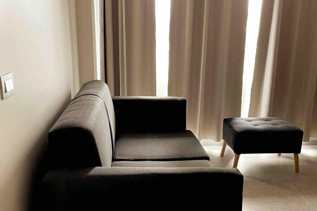 een woonkamer met een bank, een stoel en een raam bij Incredible apartment, front beach la horseshoe 