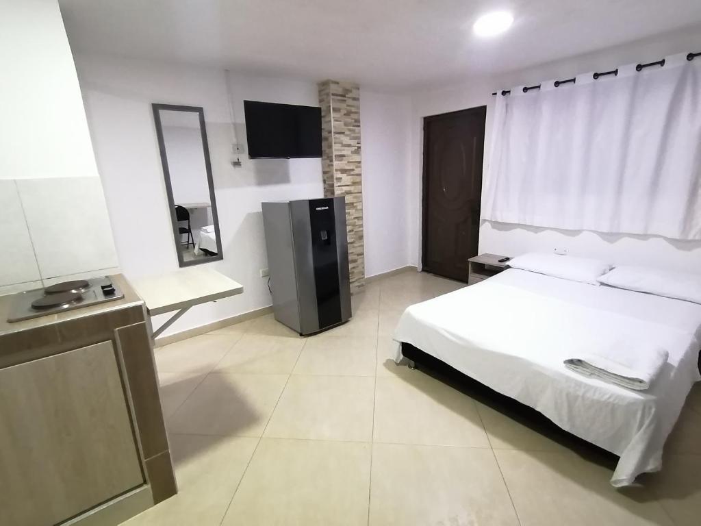 a bedroom with a white bed and a television at Tu Loft Ideal Amoblado, Wifi, Parqueadero y Confort in Bucaramanga