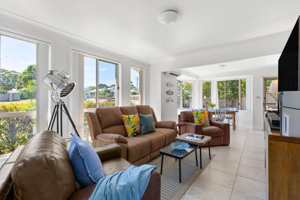 ein Wohnzimmer mit zwei Sofas und einem Fernseher in der Unterkunft Sunny Days Villa Vincentia in Vincentia