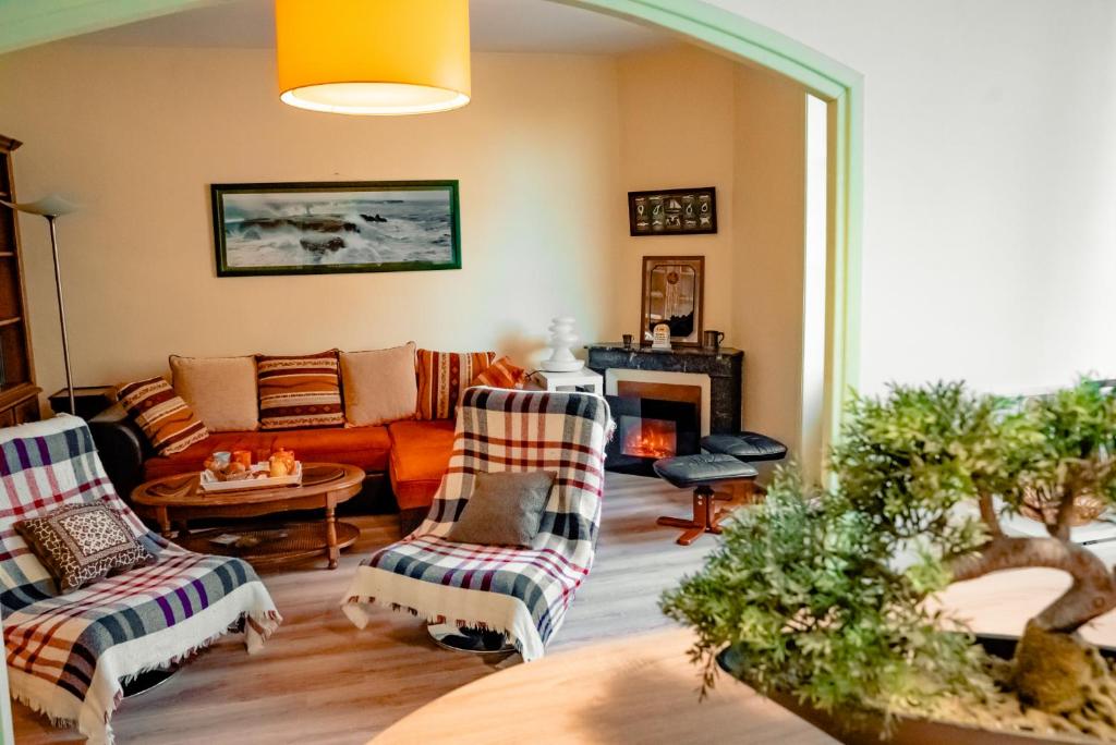 ein Wohnzimmer mit zwei Stühlen und einer Couch in der Unterkunft La Tanière du Corsaire - Coliving - jusqu'à 4 chambres - vue Rivière in Redon
