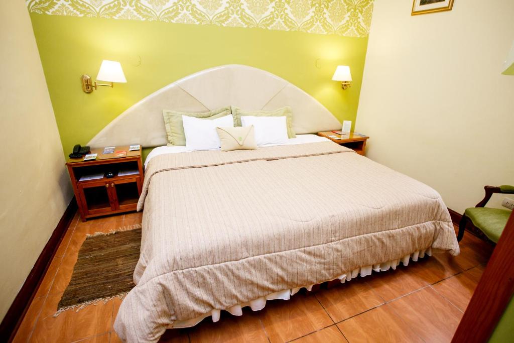 a bedroom with a large bed with a white headboard at Lima Wari Hotel Boutique in Lima