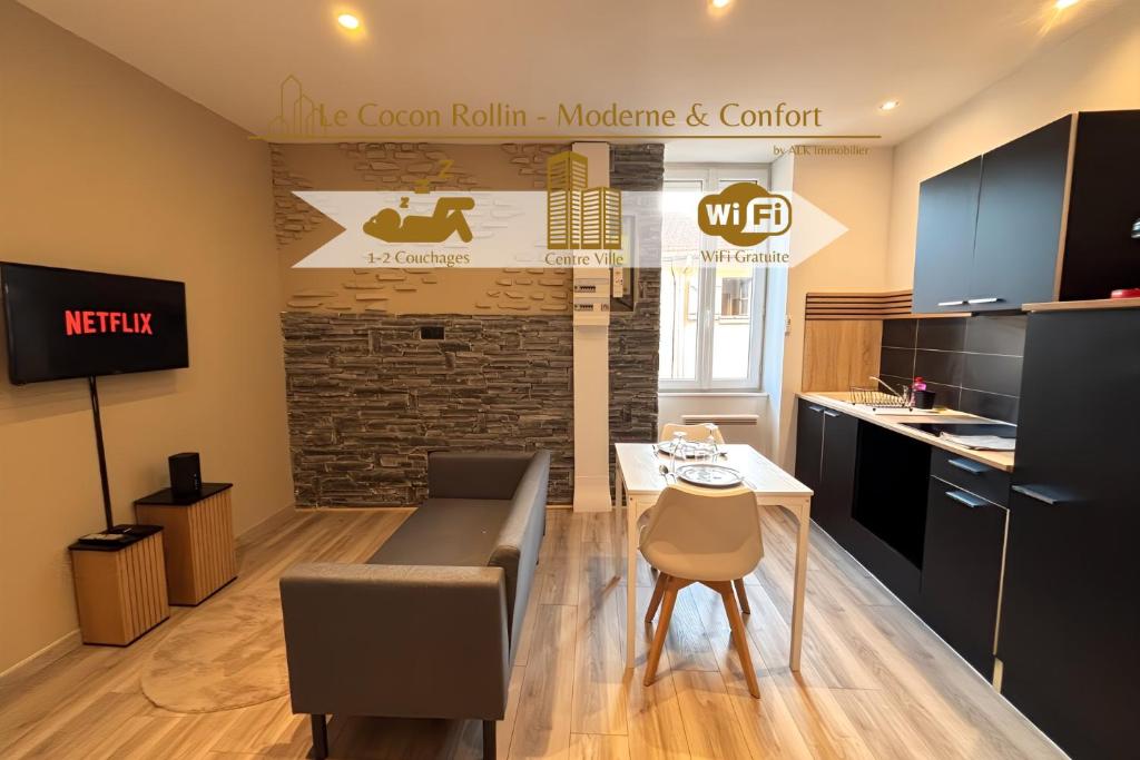een kamer met een keuken met een tafel en stoelen bij Le Cocon Rollin - Moderne & Confort in Roanne
