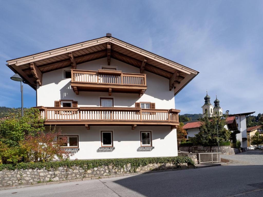 a white building with a balcony on top of it at Föchlhaus am Marktgraben in Hopfgarten im Brixental