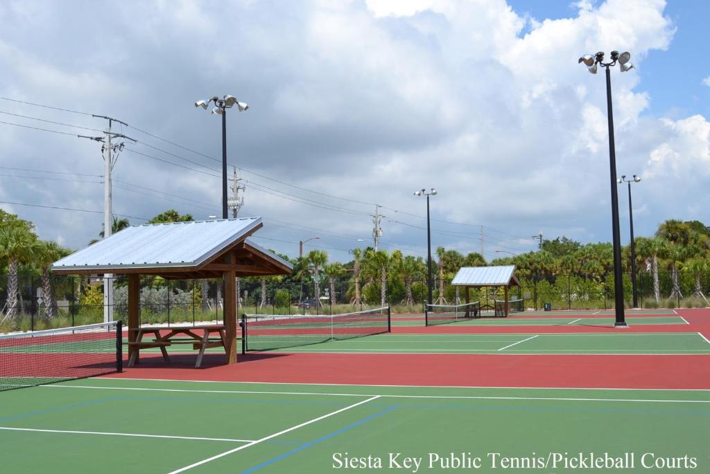twee tennisbanen met banken op een tennisbaan bij Blue Ocean Suites by Beachside Management in Siesta Key
