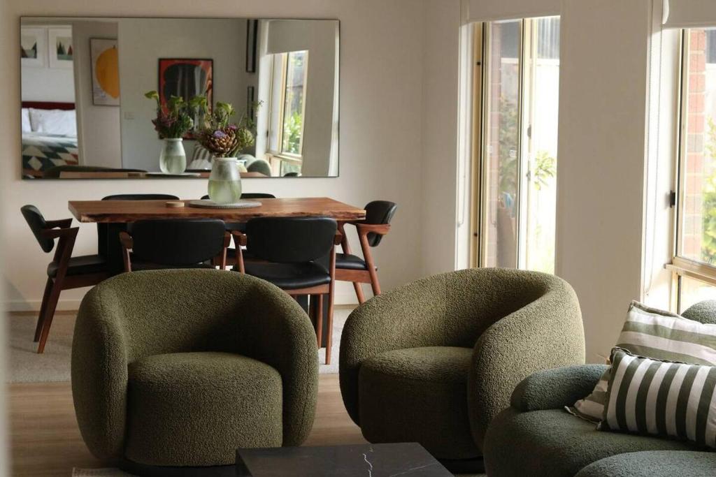 a living room with a table and chairs and a table and chairs at Senja in Torquay