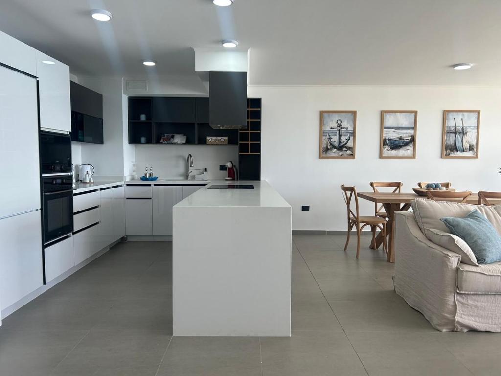 Departamento Familiar Premium Vista Mar Playa Blanca في Playa Blanca: مطبخ أبيض مع أريكة وطاولة