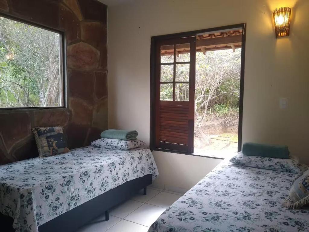 duas camas em um quarto com janela em Espaço Gaia em Palmeiras