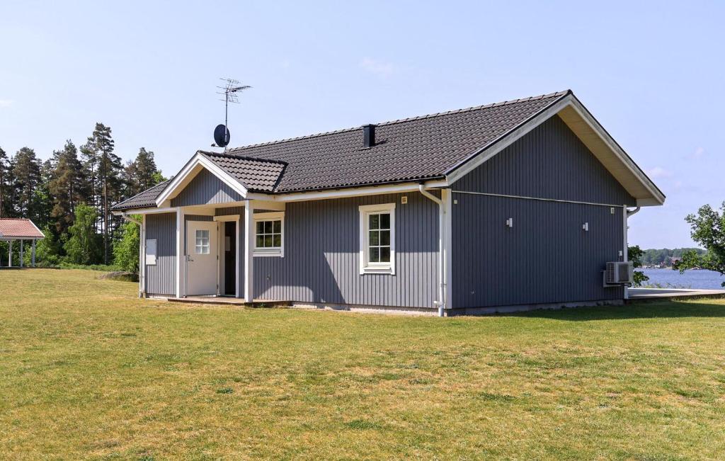 Beautiful Home In Bolmsö With Wifi في Bolmsö: منزل رمادي صغير مع ساحة كبيرة