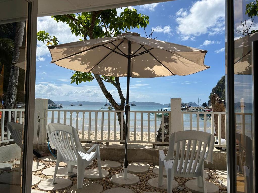 a patio with a table and chairs and an umbrella at El Nido, Corong Corong Pier in El Nido