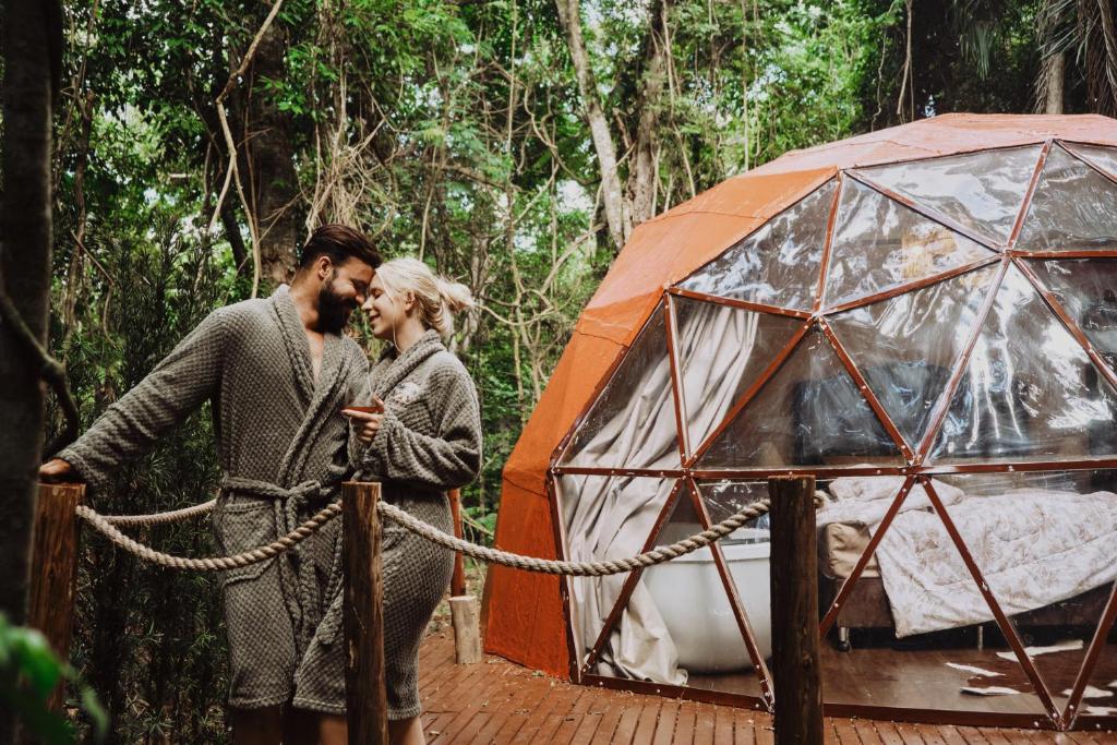 a man and woman standing in front of a tent at Cabana winchesters - Domo in Cascavel