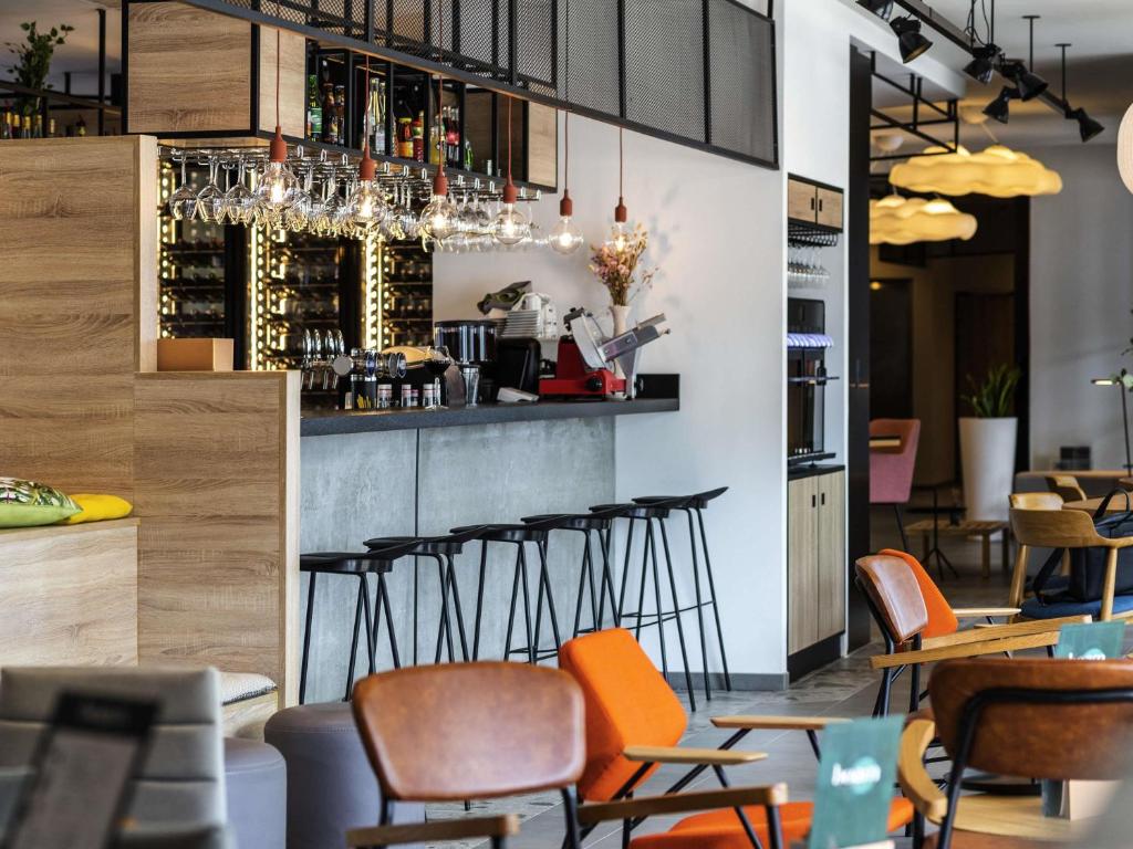 un bar en un restaurante con sillas naranjas en ibis Lyon Sud Oullins, en Oullins