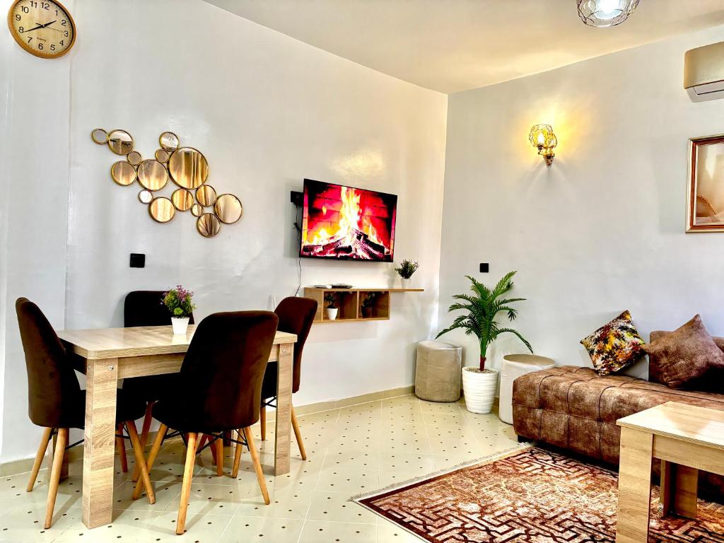 een woonkamer met een tafel en een bank bij Zyarat Marrakech in Marrakesh