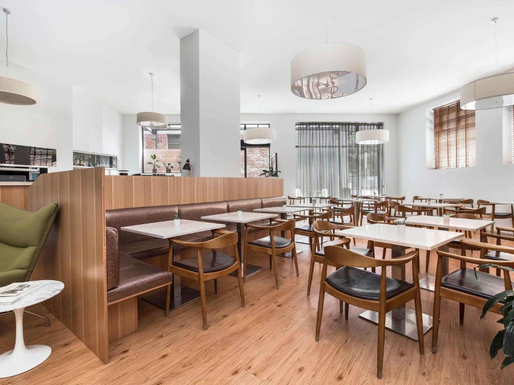 a dining room with wooden tables and chairs at Mantra Collins Hotel in Hobart