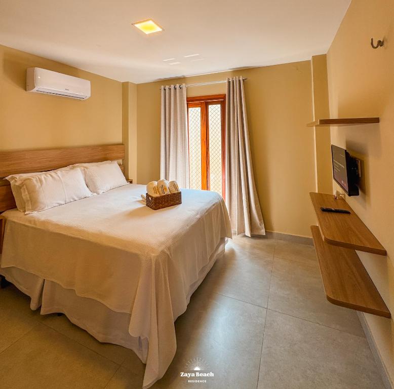 una camera da letto con un letto con un cesto sopra di Zaya Beach Residence a Icaraí