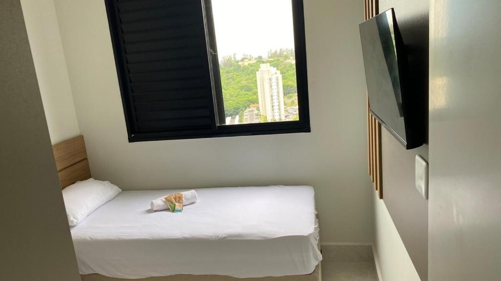 a small bed in a room with a window at Apartamento campinas lado Puc 2 in Campinas