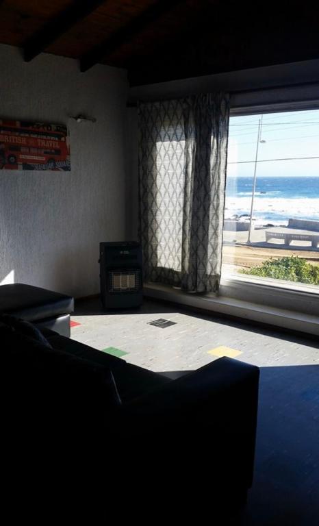 a room with a large window with a view of the ocean at El Quisco vista hermosa in El Quisco