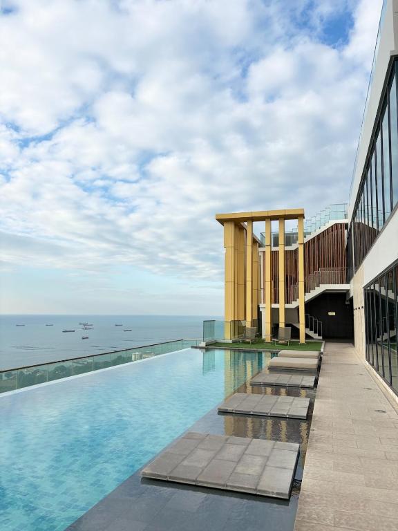 a swimming pool on top of a building with the ocean at The Sriracha Perch in Ban Fang Daeng